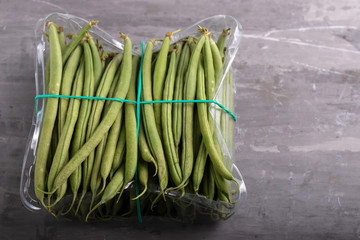 Poster - green beans in plastic box on ceramic background