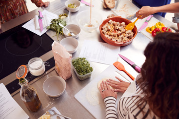 Wall Mural - Close Up Of Female Teacher Demonstrating How To Use Dough To Make Flatbread In Cookery Class