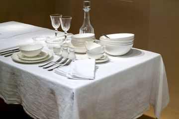 White craft plate, cutlery and napkin on white table