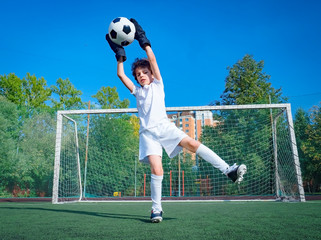 Wall Mural - Young soccer goalie attempting to make a save. little soccer goalkeeper with gloves. Kids - soccer champion. Boy goalkeeper in football sportswear on stadium with ball. Sport concept. Selective focus.