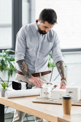 Wall Mural - handsome virtual reality architect looking at blueprint in office