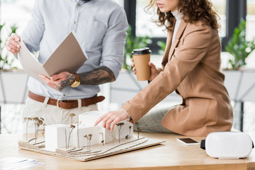 Wall Mural - cropped view of virtual reality architects pointing with finger and looking at model of house