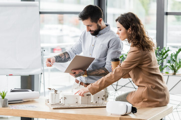 Wall Mural - virtual reality architects talking and pointing with finger at model of house