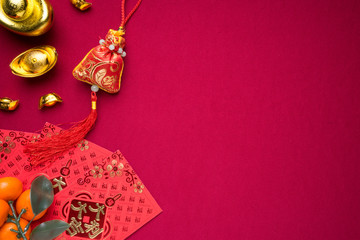 Chinese New Year decorations with red background with assorted festival decorations. Chinese characters means abundant of wealth, prosperity and luck. Flat lay or top view. 