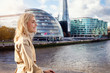 Glückliche, blonde Frau schaut auf die Skyline von London, Großbritannien
