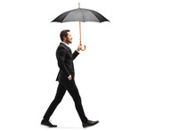 Handsome Businessman Walking With An Open Umbrella