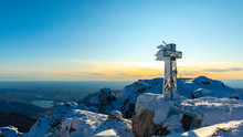 View Over Snowy Mountains With A Frozen Summit Cross