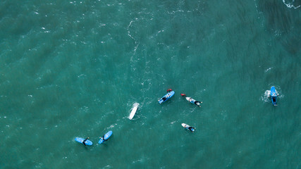 Wall Mural - Aerial view of surfer swimming on board near huge blue ocean wave in Porto da Cruz, Madeira island, Portugal