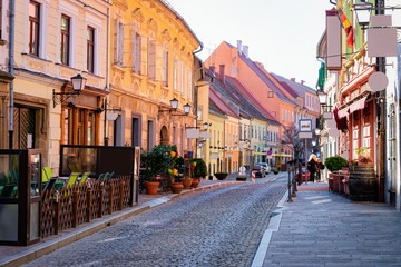 Canvas Print - Street cafes with tables and chairs in Ptuj old town center in Slovenia. Architecture and restaurants in Slovenija. Travel