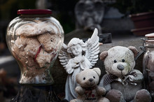 Teddy Bears, Angel And Other Toys On Baby Grave In The Cemetery. Сlose-up. (concept: Death, Loss).