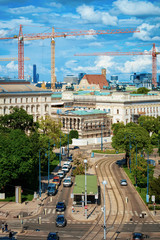 Wall Mural - Skyline and cityscape of road with car transport on Museumstrasse in Vienna in Austria. Wien in Europe. Street view on Parliament and construction works. Building architecture. Blue sky with clouds.