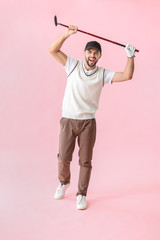 Wall Mural - Handsome happy male golfer on color background