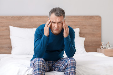 Sticker - Mature man suffering from head ache in bedroom