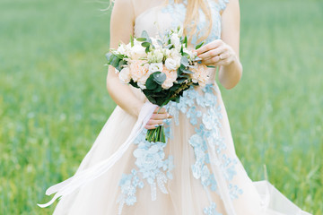 The bride touched his hand to a delicate and beautiful bouquet