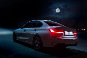 Wall Mural - car moves on the road on a moonlit night.