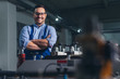 © zorandim75 - Cheerful factory worker with arms crossed.