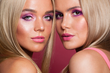 Wall Mural - Two women faces. Attractive models with vivid fashion makeup, close up portrait