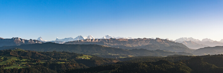 Wall Mural - swiss mountain range in switzerland while the valley is covered in fog during sunset, super warm lig