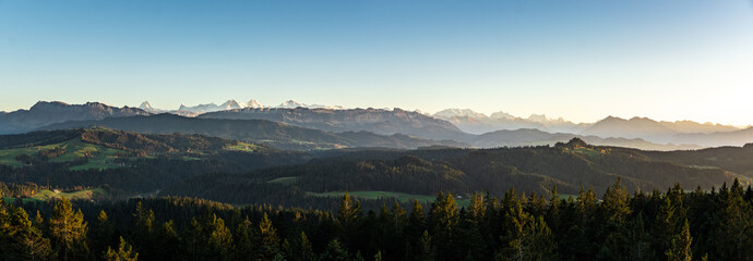Canvas Print - swiss mountain range in switzerland while the valley is covered in fog during sunset, super warm lig