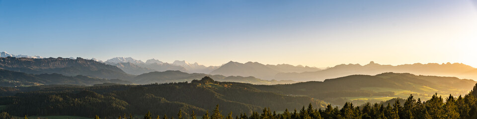 Wall Mural - swiss mountain range in switzerland while the valley is covered in fog during sunset, super warm lig