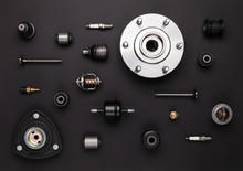 Studio Photography - A Lot Of Automotive Parts: Valves, Spark Plugs, Silent Blocks, Thermostats,  Sensors, Wheel Hub, Bearings, Lie In Straight Rows On A Flat Surface Isolated On A Black Background.