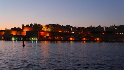 Wall Mural - Pan along capital city of Valletta in Malta and the Grand Harbour at dusk