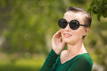 Wall Mural -  fashion outdoor photo of beautiful young woman with short hair in luxurious green dress and flowers on face