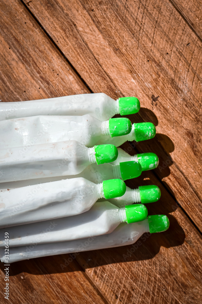 Pan wala Chuna, Limestone Powder in Plastic tube,Limestone powder on  wood,indian tobacco chuna tube,water mix limestone powder, Stock Photo