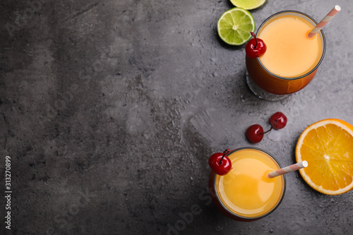 Fotografía Fresh alcoholic Tequila Sunrise cocktails on grey table, flat lay