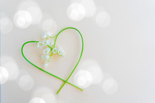 Lilies Of The Valley In The Shape Of A Heart On A Pink Background.
