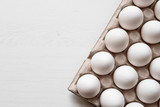 Detail of white chicken eggs in paper tray.