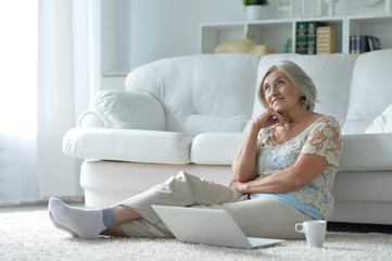 Portrait of a beautiful senior woman with laptop