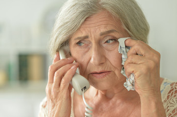 Wall Mural - Close up portrait of upset senior woman calling doctor