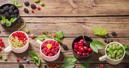 Wall Mural - different berries on old wooden background