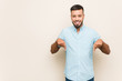 © Asier - Young south-asian man points down with fingers, positive feeling.
