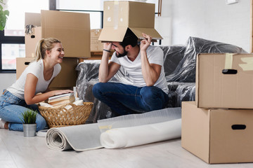 Happy young couple unpacking or packing boxes and moving into a new home 