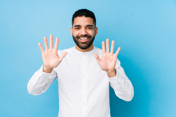 Wall Mural - Young latin man against a blue  background isolated showing number ten with hands.