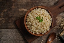 Bowl Of Cooked Whole Grain Brown Rice  On Wooden Background Overhead View