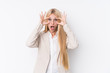 © Asier - Young business blonde woman on white background keeping eyes opened to find a success opportunity.