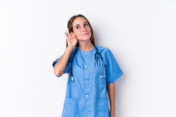 Wall Mural - Young nurse woman isolated trying to listening a gossip.