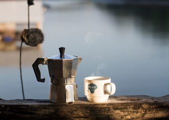 Wall Mural - Morning hot coffee with traditional coffee pots The background image is a sea view.