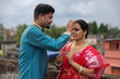 © abir - A brunette Indian Bengali romantic couple in traditional wear interacting between themselves on a roof top in romantic mood in the morning of Durga Puja festival in urban background. Indian lifestyle.