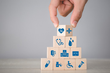 Health Insurance Concept,hand arranging wood block stacking with icon healthcare medical.