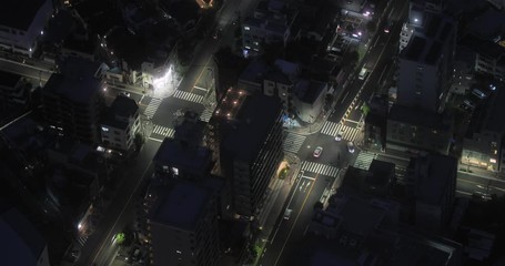 Wall Mural - Urban road intersection with passing cars at night