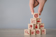 © A Stockphoto - Hand arranging wood block stacking with icon arrow and business,targeting the business concept.