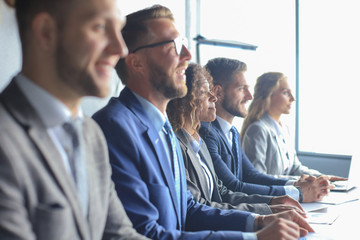 Image of row of business people working at seminar.