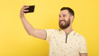 © lashkhidzetim - Handsome young man taking selfie on color background.