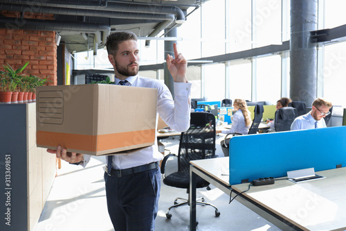 Fotomural Dismissed worker going from the office with his office supplies showing fuck