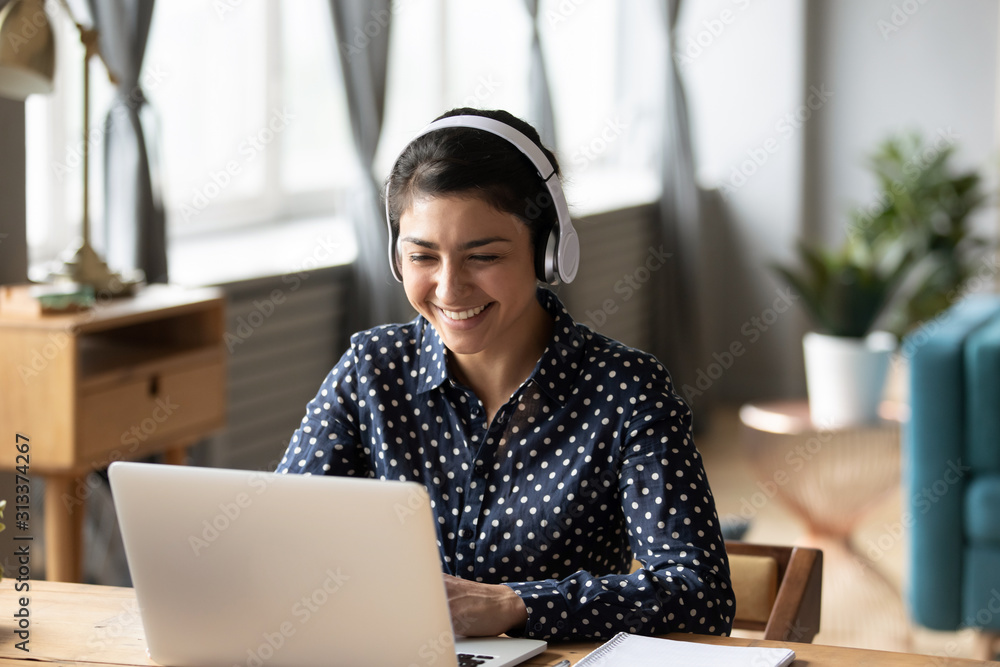 Happy indian young girl wear headphones watching listening online course - obrazy, fototapety, plakaty 