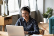 © fizkes - Happy indian young girl wear headphones watching listening online course